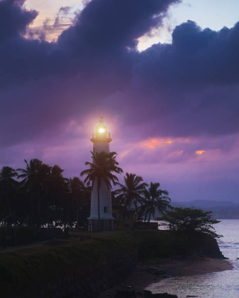 istock Galle Fort Lighthouse Illuminated at Sunset with Dramatic Clouds and Palms 2177639742