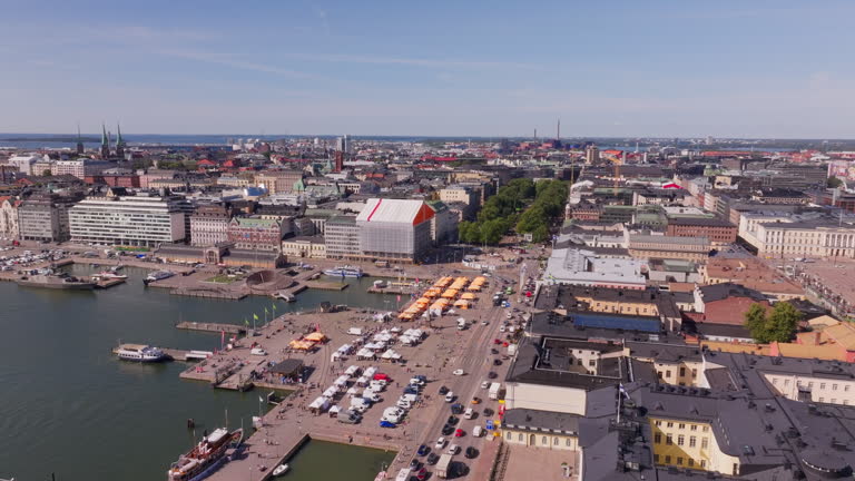 Aerial views highlight Helsinki's lively city center, showcasing the bustling Market Square, Uspenski Cathedral, and the scenic Baltic Sea, all beneath a sunny sky with fluffy clouds