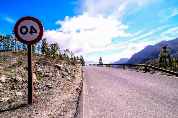 A road with a sign that says 0.4. The road is empty and the sky is blue
