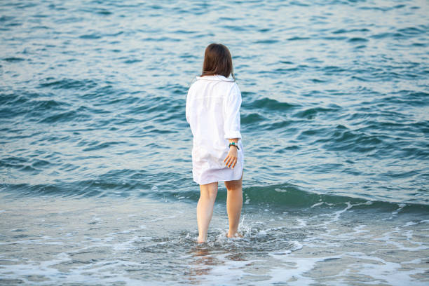 istock Young woman with arms apart on sand beach 2177646204