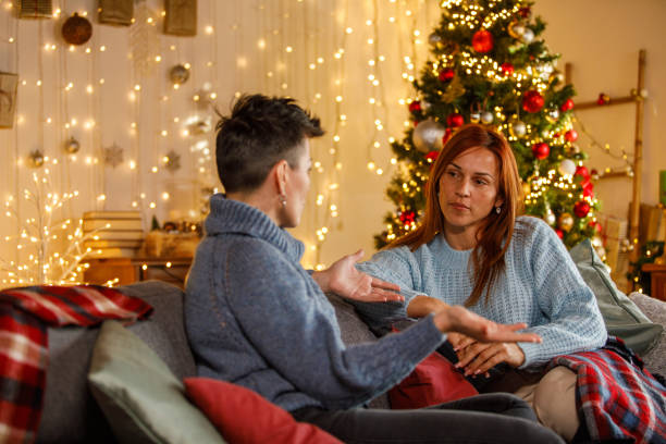 istock Two friends enjoying Christmas at home by the festive tree 2177648000