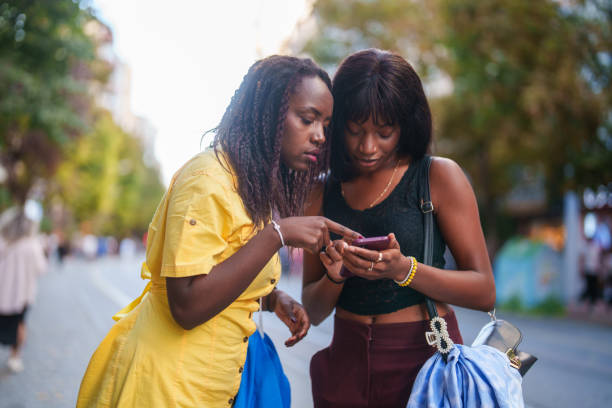 istock Two black young female using mobile phone in downtown city streets. 2177649259