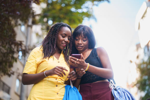 istock Two black young female using mobile phone in downtown city streets. 2177649498