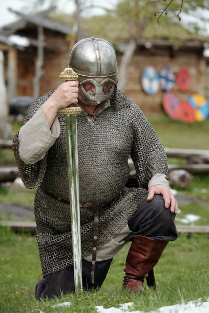 istock Kneeling Medieval Warrior Holding Sword in Battle Armor 2177650744