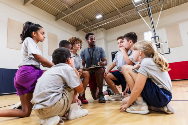 istock Coach huddling with group of students in school gym 2177650911