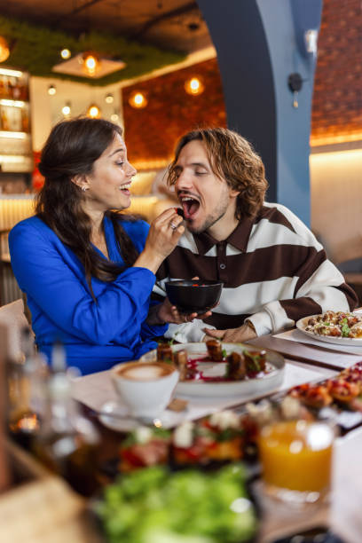 istock Couple feeding eachother in a restaurant with delicious food. 2177651649