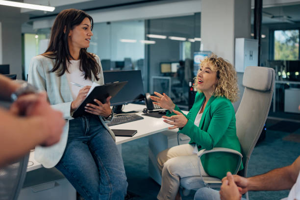 istock A woman manager of a modern office space is holding some documents while talking to a female colleague at a business meeting 2177653526