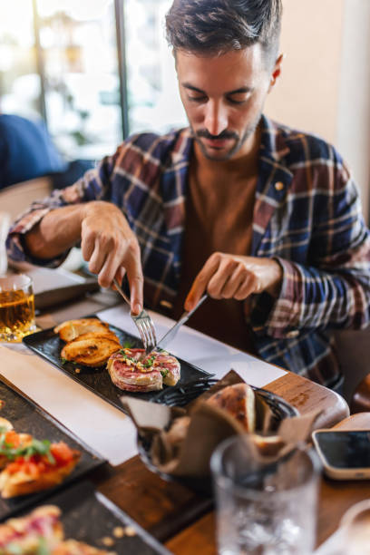 istock Man cutting delicious food with knife and fork in a restaurant. 2177654068