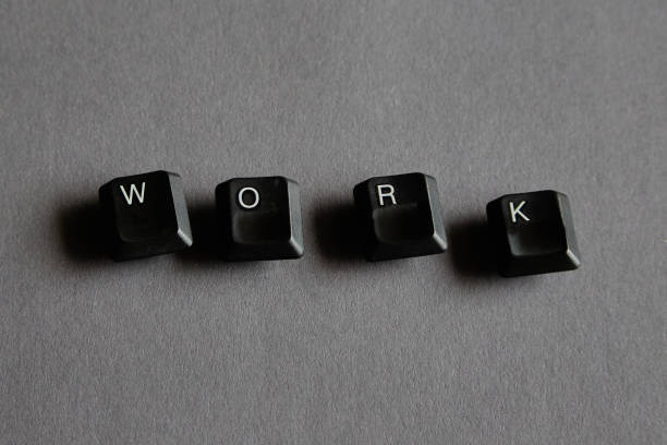 Black keys with the letters W, O, R, K on a gray background, the letters from a computer keyboard form the word \
