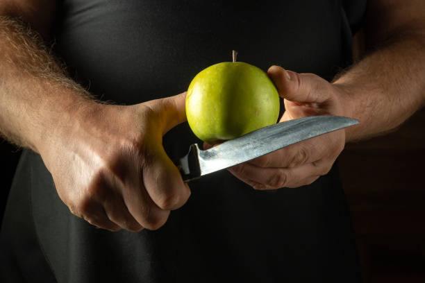 istock Peeling green apple with knife in chef hands. Apple pie cooking concept. Healthy dinner with apples 2177656251