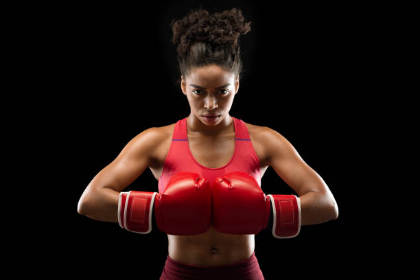 istock Woman professional boxer posing over black background 2177656618
