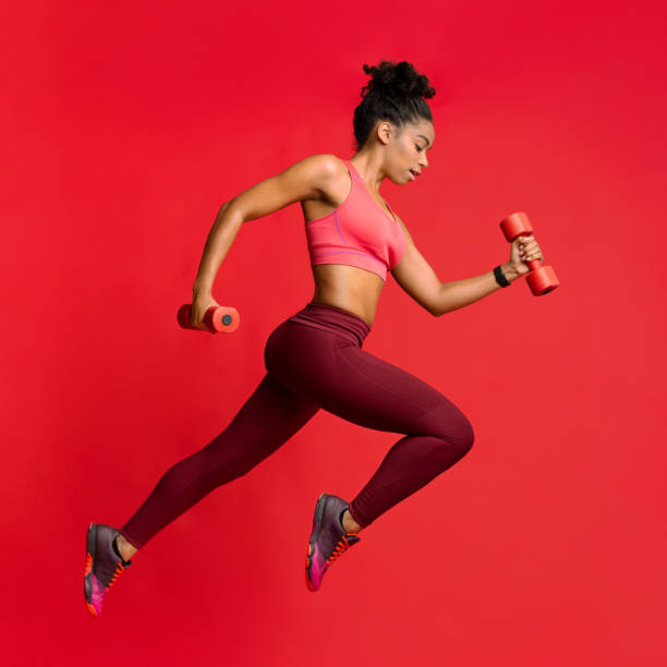 istock Active african woman training wth dumbbells over red background 2177657107