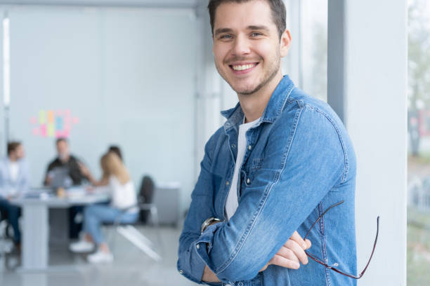 istock Young confident entrepreneur standing in modern office smiling and looking at camera 2177657466