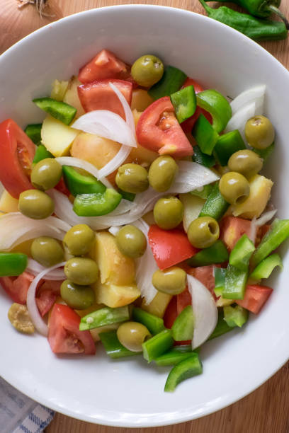 Bowl of salad with stewed potatoes and olives