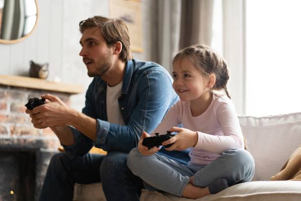 istock Young man and little girl playing computer game with gaming console. 2177657934
