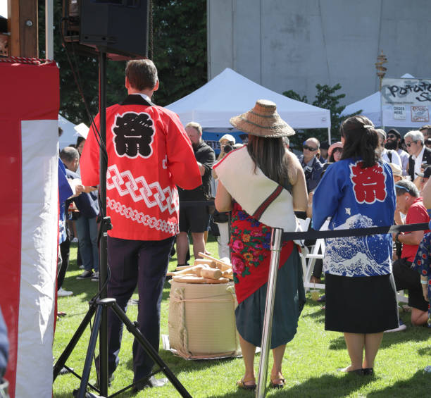 A young male tourist is wearing mawashi and experiencing Japanese historical traditional wrestling sumo from an ex professional sumo wrestler in dohyo.