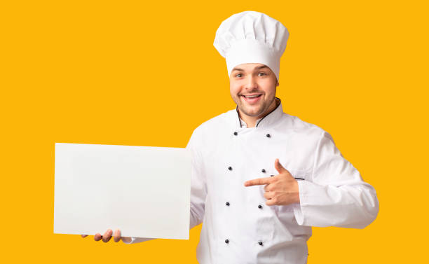 istock Chef Man Showing Empty White Board Standing Over Yellow Background 2177661538