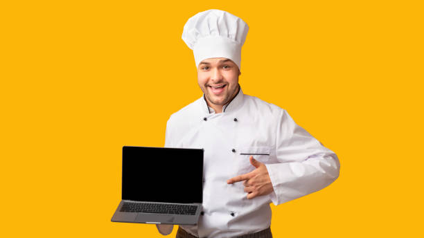 istock Chef Showing Laptop With Empty Screen Standing, Yellow Background, Panorama 2177661542