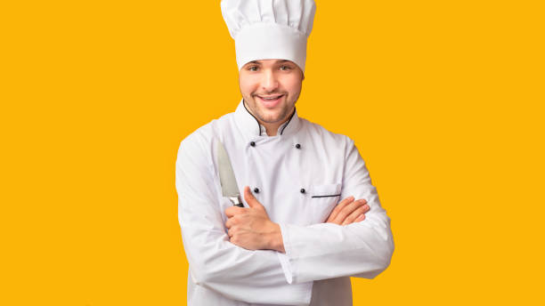 istock Professional Chef Posing Holding Kitchen Knife, Yellow Background, Panorama 2177661560