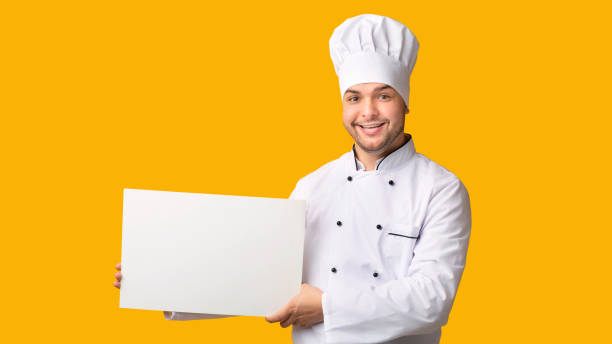 istock Chef Holding Blank White Poster Standing Over Yelllow Background, Panorama 2177661583