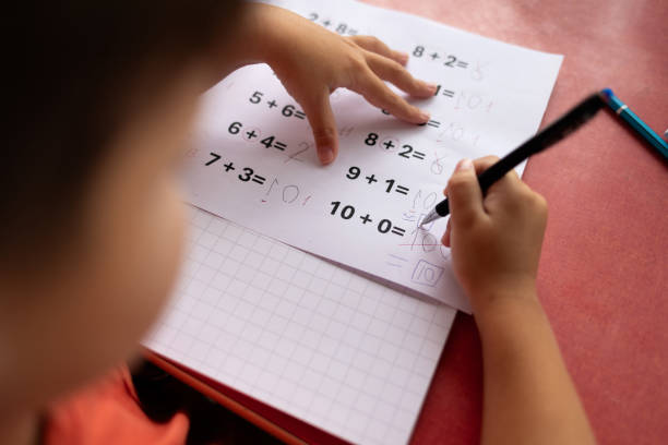 istock Over the shoulder view of a child who has dyslexia and dyscalculia doing math homework. 2177663570