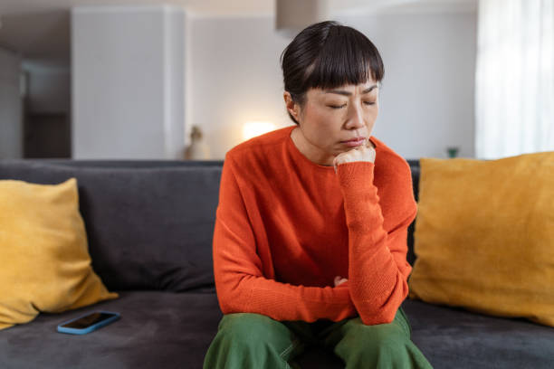 istock Sad and lonely Japanese woman sitting on a sofa 2177668192
