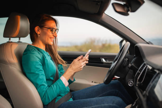 istock Young woman using her phone in the car at sunset. 2177668711