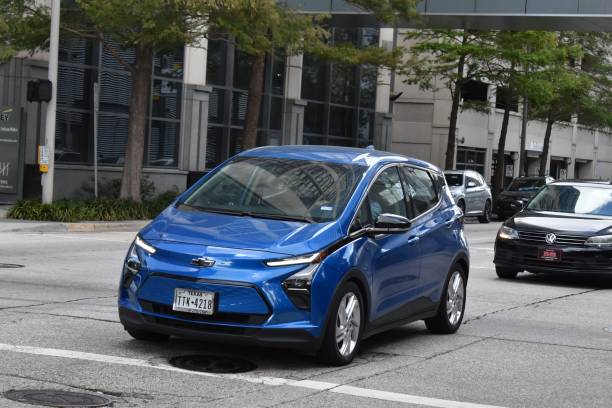 A blue Chevy Bolt EV, cruising in the downtown financial district of the city. Houston, TX USA 10-4-2024 - A blue Chevy Bolt economy car, cruising in the downtown financial district of the city. small florida home stock pictures, royalty-free photos & images