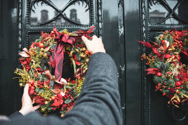 istock Man decorating house front door fir Christmas 2177672921