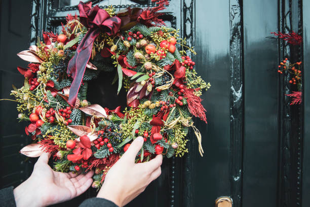 Man decorating house front door fir Christmas