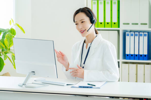 medical personnel operator wearing a white coat - オンライン診療 ストックフォトと画像