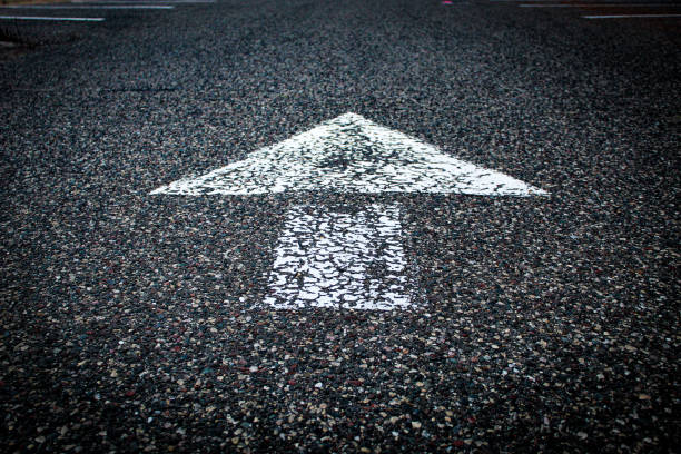 istock low angle closeup of white painted arrow on asphalt road 2177676138