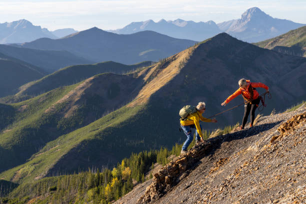istock Mature mountain climber offers helping hand 2177677820