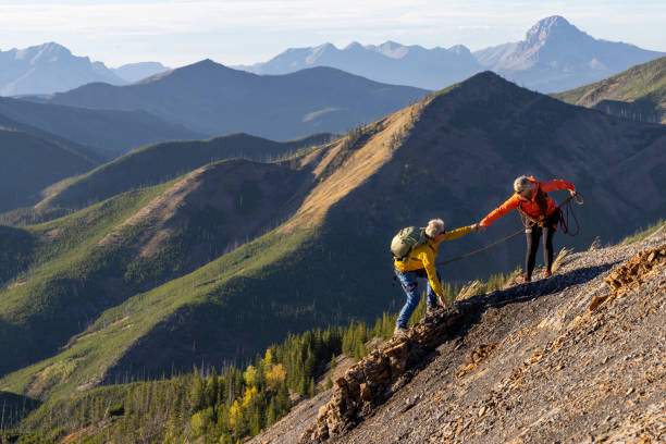 istock Mature mountain climber offers helping hand 2177677826