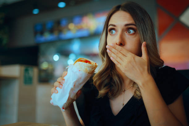 istock Restaurant Customer Covering her Mouth After Biting a Meal 2177680228