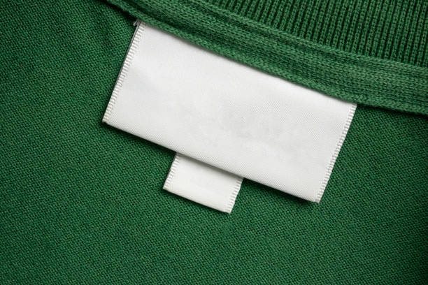 istock Blank white laundry care clothes label on green shirt fabric texture background 2177680952