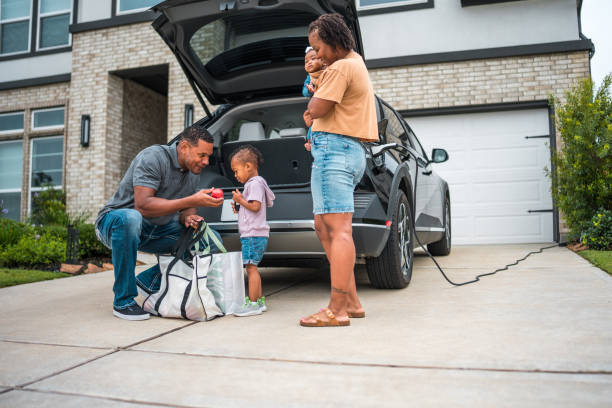 istock Diverse Family Unloading Eco-friendly Shopping Next to Electric Car 2177681106