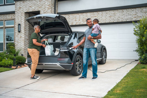 istock Diverse Family Engaged in Unloading Groceries by an Electric Car 2177681115