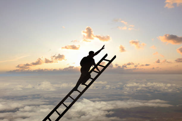 Success concept with people silhouette climbing stairs in the sunset