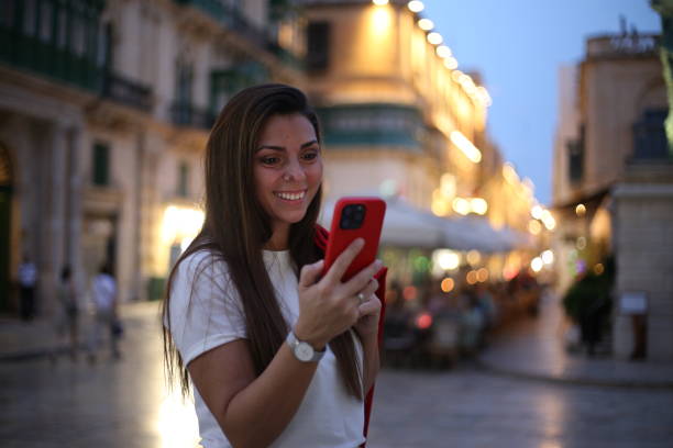istock Beautiful woman using mobile phone on a city street. 2177682200