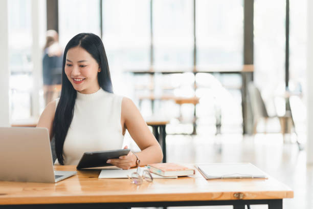 istock A woman working on laptop and tablet in bright office space 2177683895