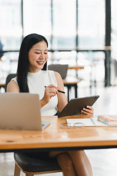 istock A woman is happily working on tablet in modern office space. 2177683915