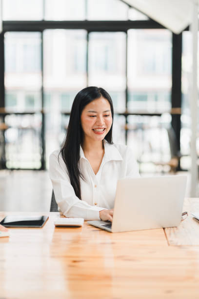 istock Efficient woman working on laptop in modern office space, smiling happily. 2177683983