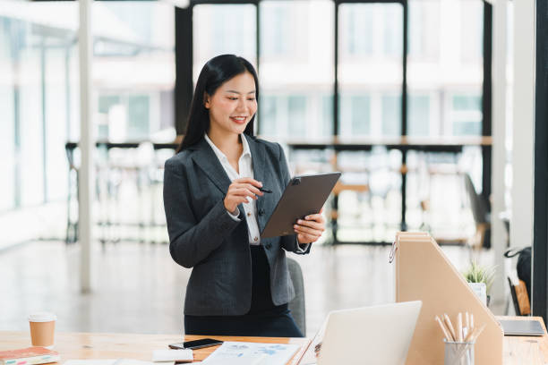 istock A professional woman in suit smiles while using tablet in modern office. 2177684045