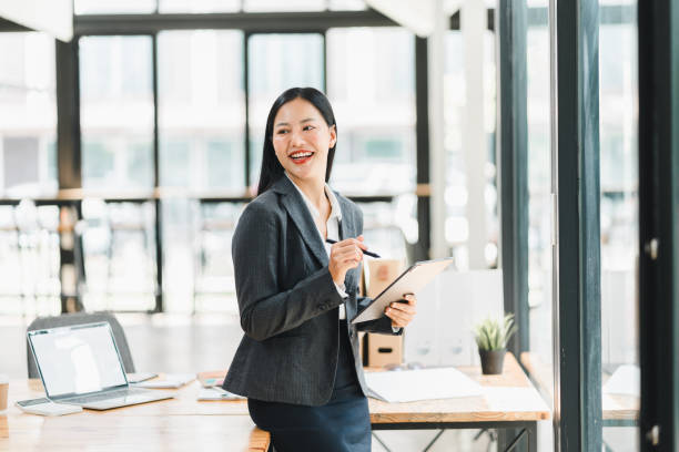 istock A confident businesswoman smiles while holding tablet in modern office. 2177684057