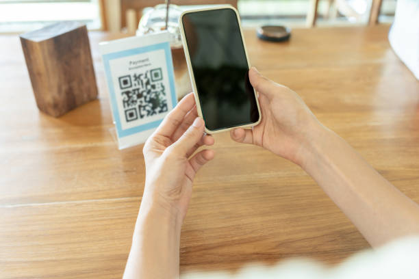 istock Woman use smartphone to scan QR code to pay in cafe restaurant with a digital payment without cash. Choose menu and order accumulate discount. E wallet, technology, pay online, credit card, bank app. 2177684374