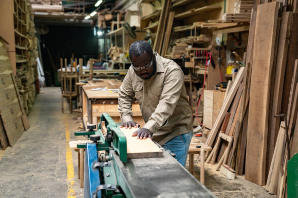 istock Carpenter cutting wood with an electric saw at his workshop 2177689424