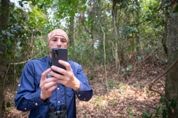 istock Man searches on smart phone to identify birds. Man in birding activity. 2177694339