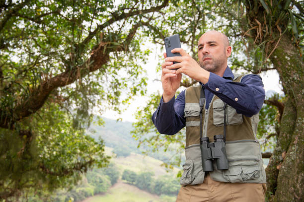 istock Man searches on smart phone to identify birds. Man in birding activity. 2177694549