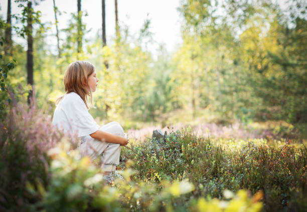 istock A young child sits peacefully among wildflowers in a serene forest during a bright summer afternoon 2177707659